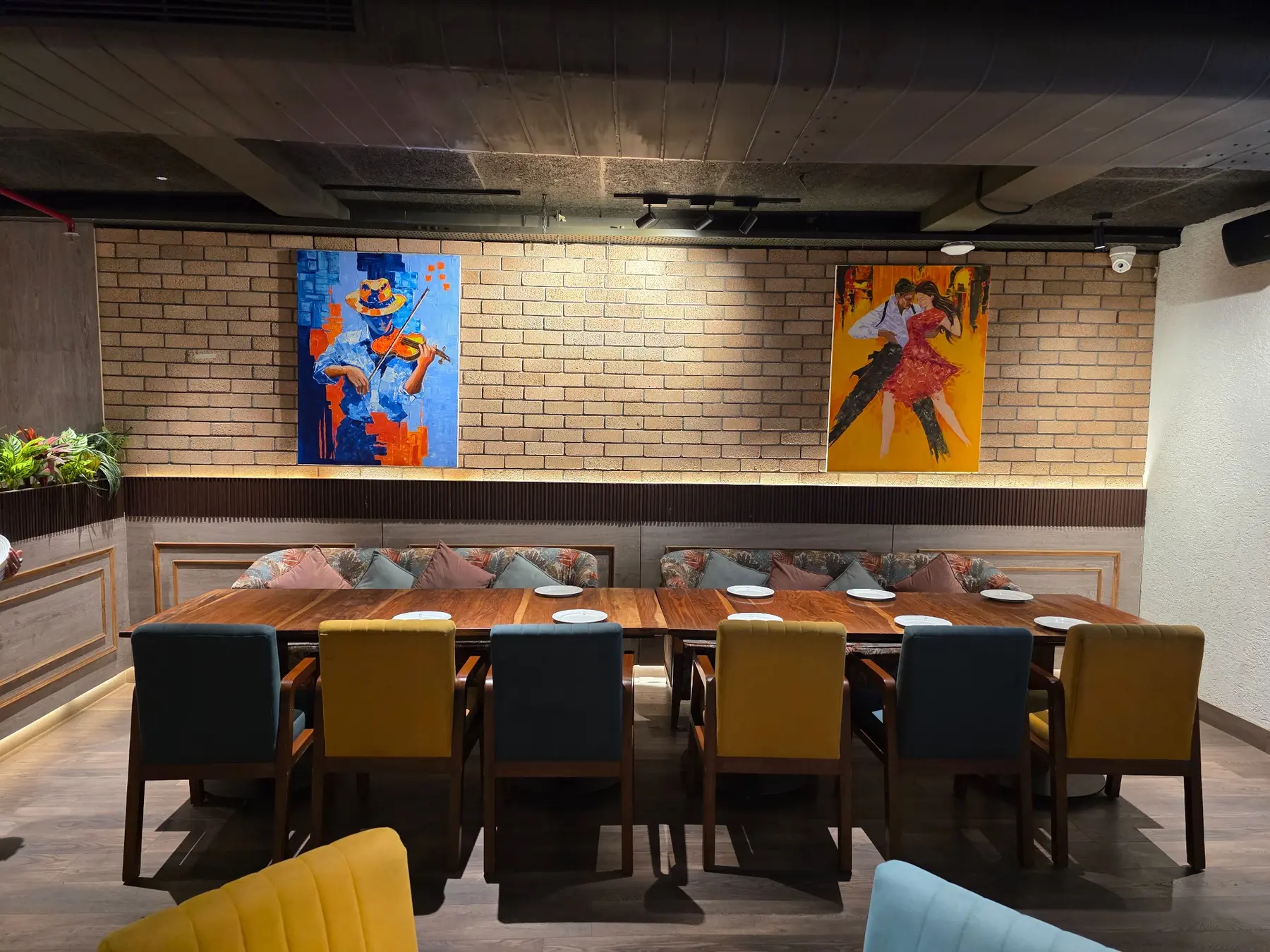 Actual basement group dining area at Nineteenth May with a long table and original artwork